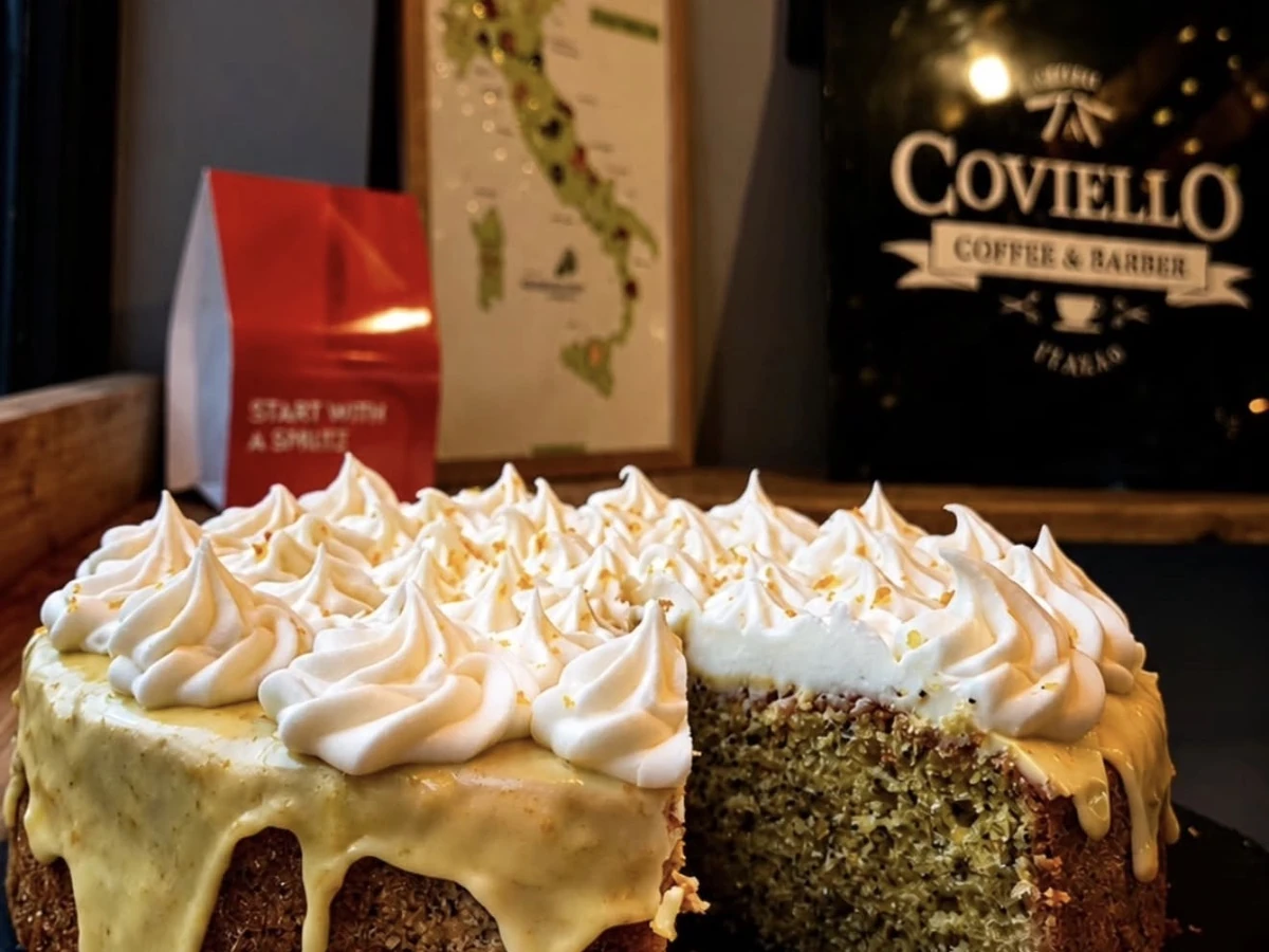 Pistachio cake topped with meringue and lemon cream on the counter at Coviello